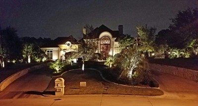 Street view of a home at night lit up by exterior LED lighting