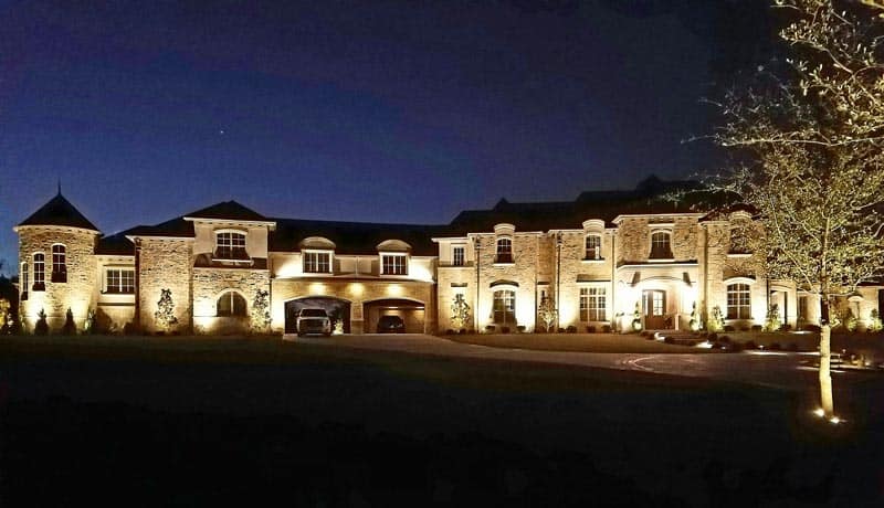 A mansion's exterior is illuminated by well designed outdoor lighting