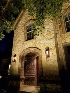 The dramatic stonework of a homes exterior seen by the light of outdoor LED lighting