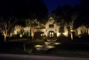 Landscaping features are visible at night by LED lighting