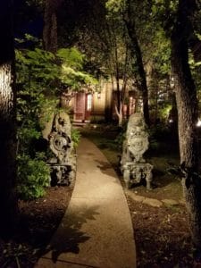 A garden path illuminated at night by landscape lighting