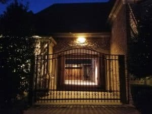 Wrought iron fence in front of well lit home