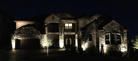 Outdoor lighting lights up a home and landscape.