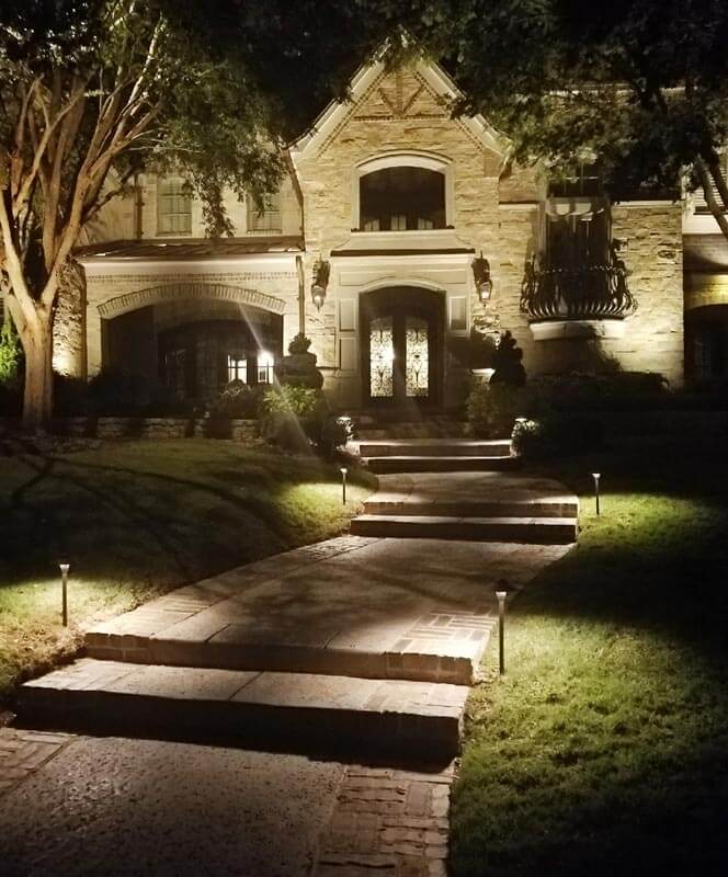 outdoor lighting lights up a home and pathway to the front door