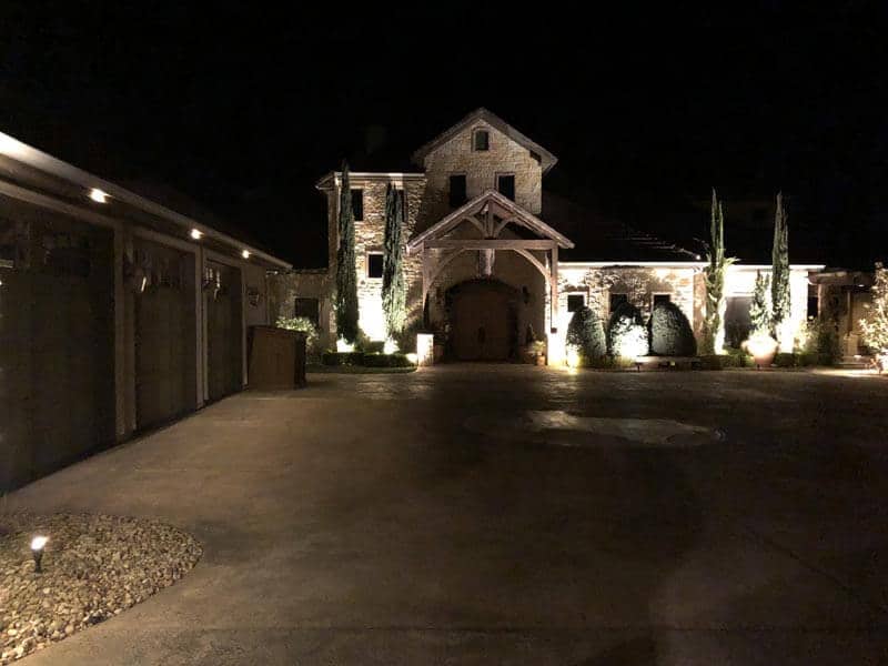 exterior lighting lights up a beautiful home and driveway
