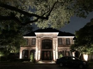 beautiful red brick home with outdoor lighting
