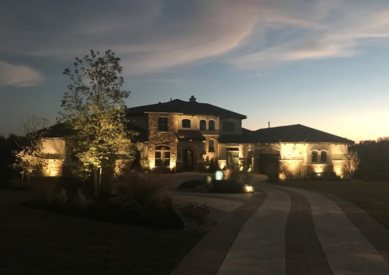 Beautiful front yard lit up with lights.