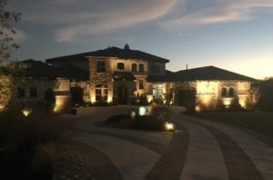 beautiful front yard lit up with lights
