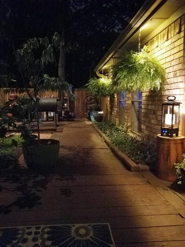 backyard patio lit up with outdoor lighting