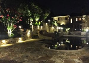 A gorgeous outdoor lighting set up around a pool. 